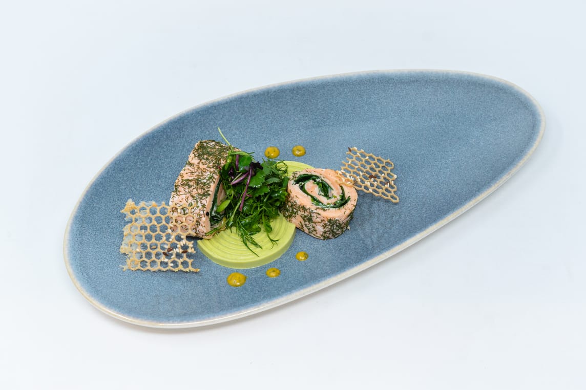 Vorspeise: Kalt geräucherte Lachsroulade mit erfrischendem Erbsen-Panna-Cotta, feinem Kräutersalat, dazu Haferflocken-Cracker und Honig-Senf-Sauce.