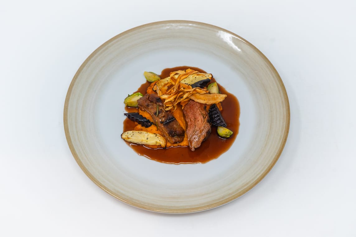Hauptgang: Veganes gegrilltes Filet mit würzigem Jus serviert auf zartem Süsskartoffel-Püree, dazu Urkarotten, Pastinaken und Rosenkohl