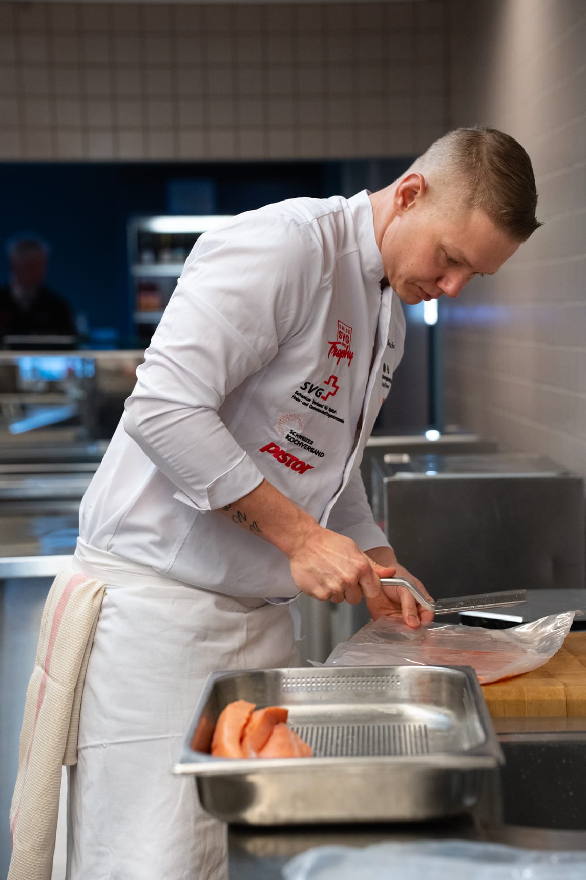 Thomas Schenk bei der Zubereitung der Vorspeise: kalt geräucherte Lachsroulade mit erfrischendem Erbsen-Panna Cotta, feinem Kräutersalat, dazu Haferflocken Cracker und Honig-Senfsauce.